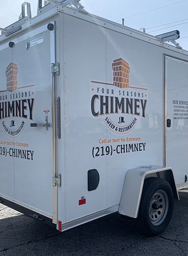 A white trailer with the word chimney on it is parked on the side of the road.