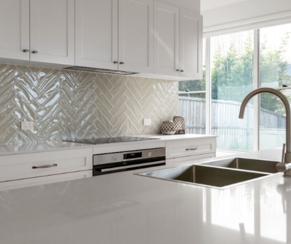 Modern kitchen with white cabinets and backsplash.