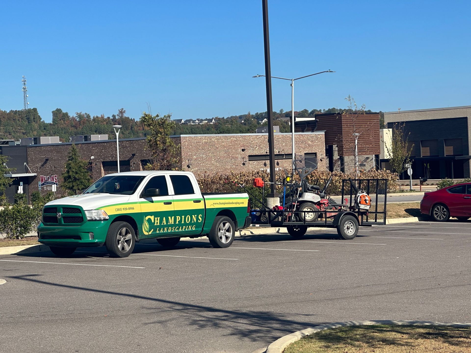 a green and white truck with the word warriors on the side is pulling a trailer .