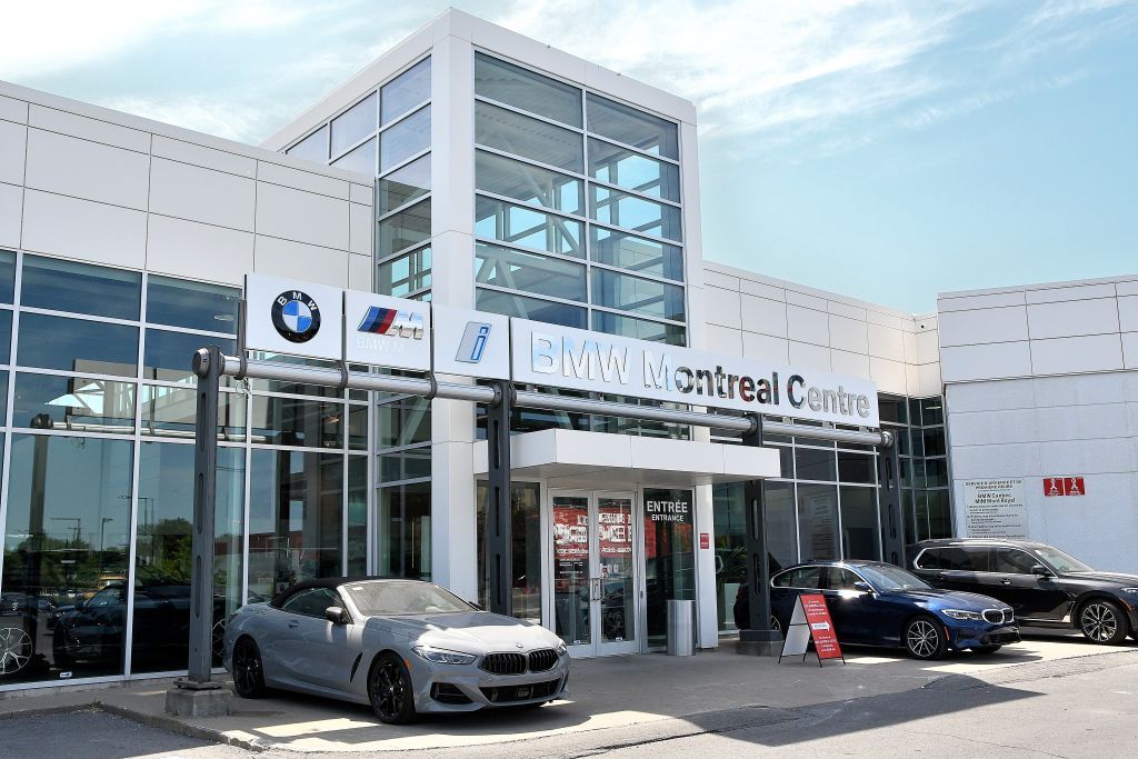 Une voiture est garée devant un concessionnaire BMW.