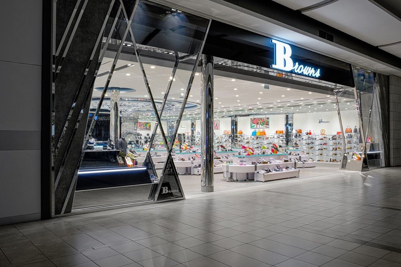 Un magasin de chaussures dans un centre commercial avec beaucoup de chaussures exposées.
