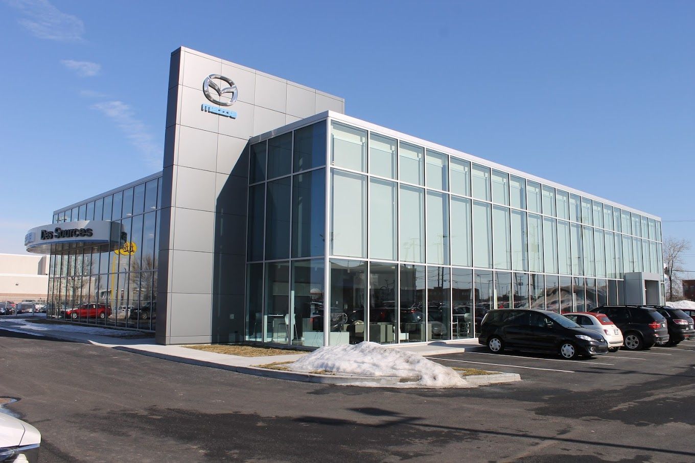 Un concessionnaire automobile Mazda avec des voitures garées devant lui