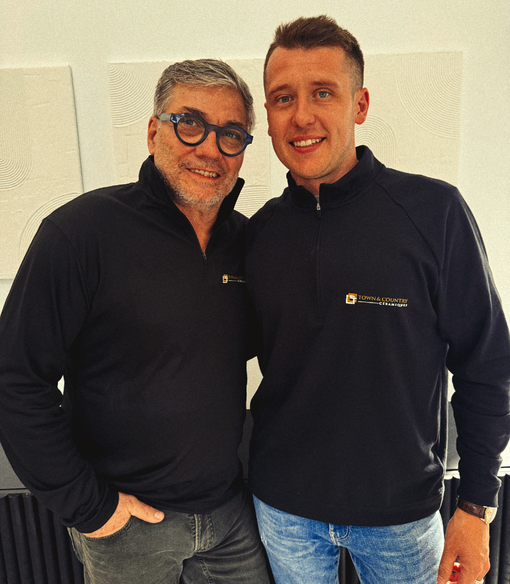 Deux hommes posant pour une photo, l'un portant des lunettes