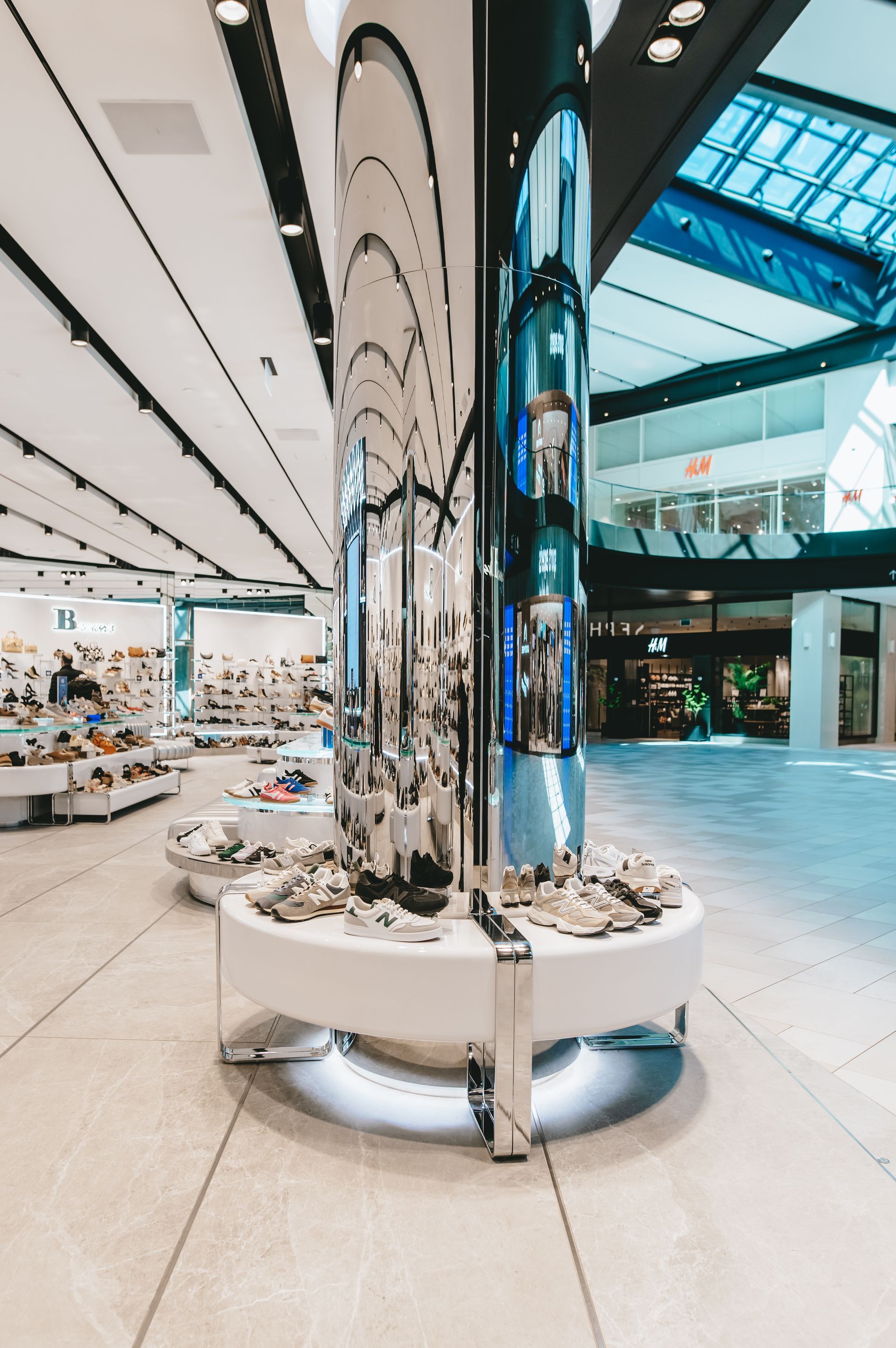 Il y a un grand pilier au milieu d'un centre commercial.