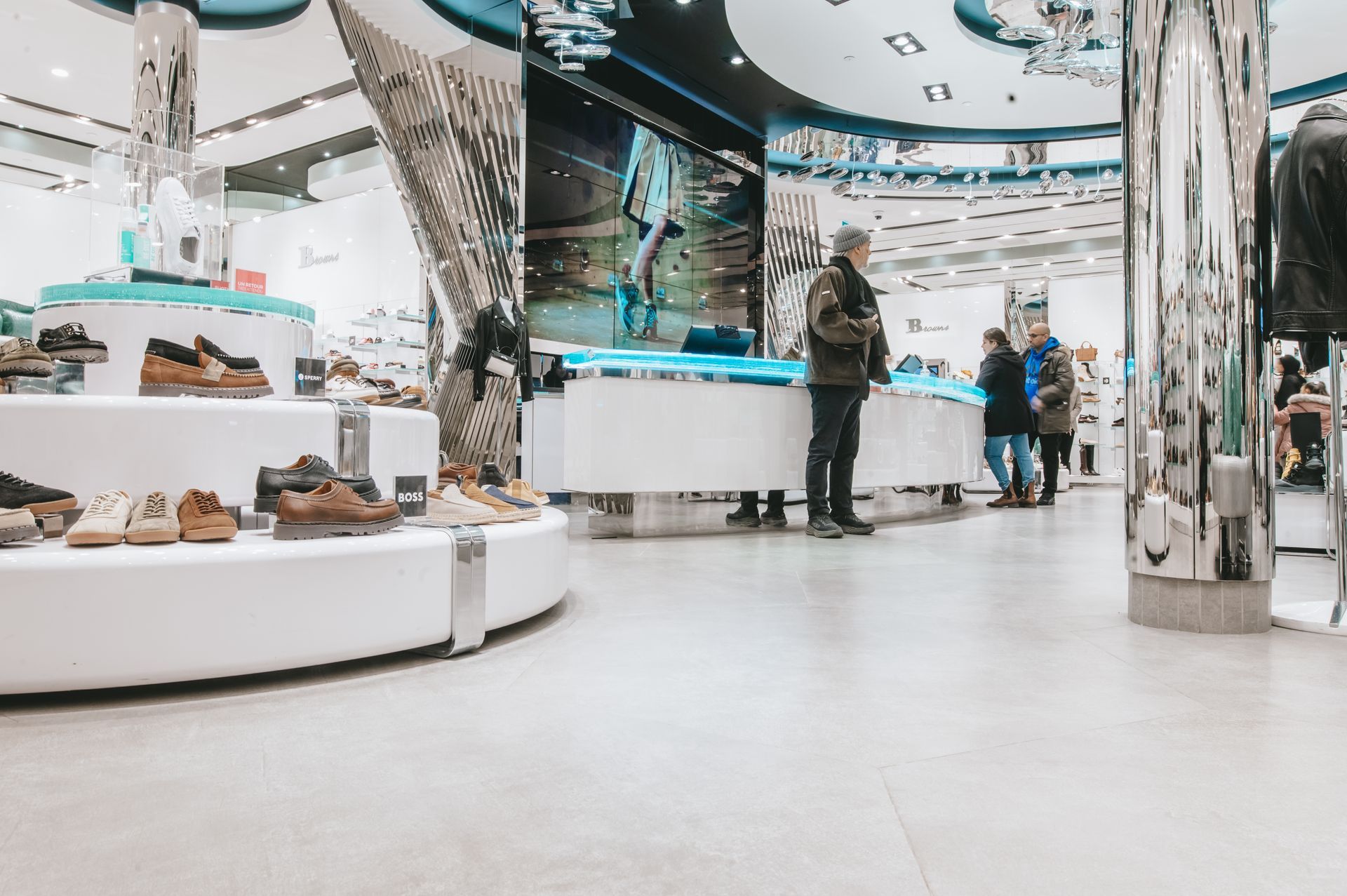 Un homme se tient debout dans un magasin de chaussures et regarde des chaussures.