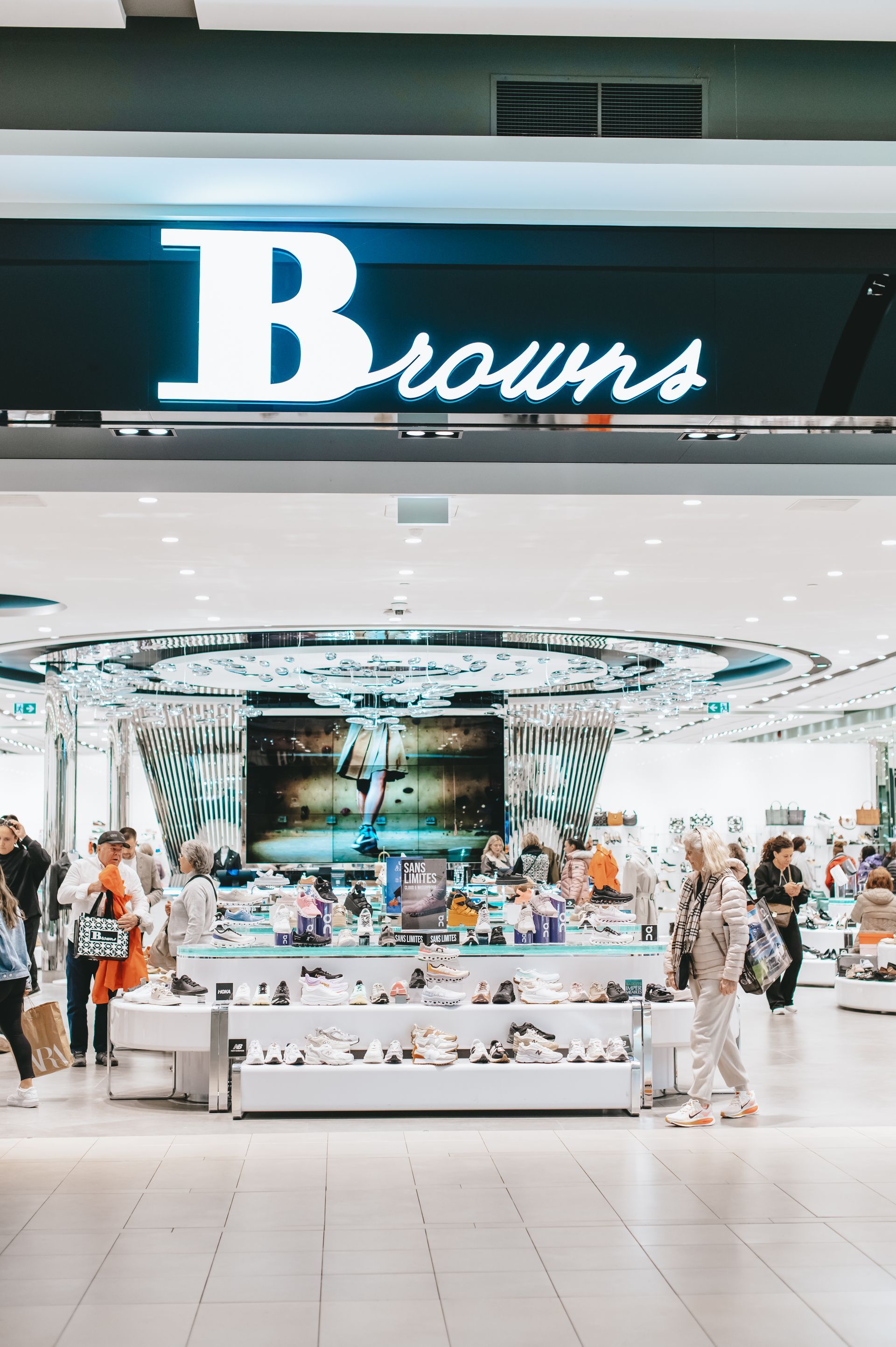 Un groupe de personnes marche devant un magasin appelé Browns.