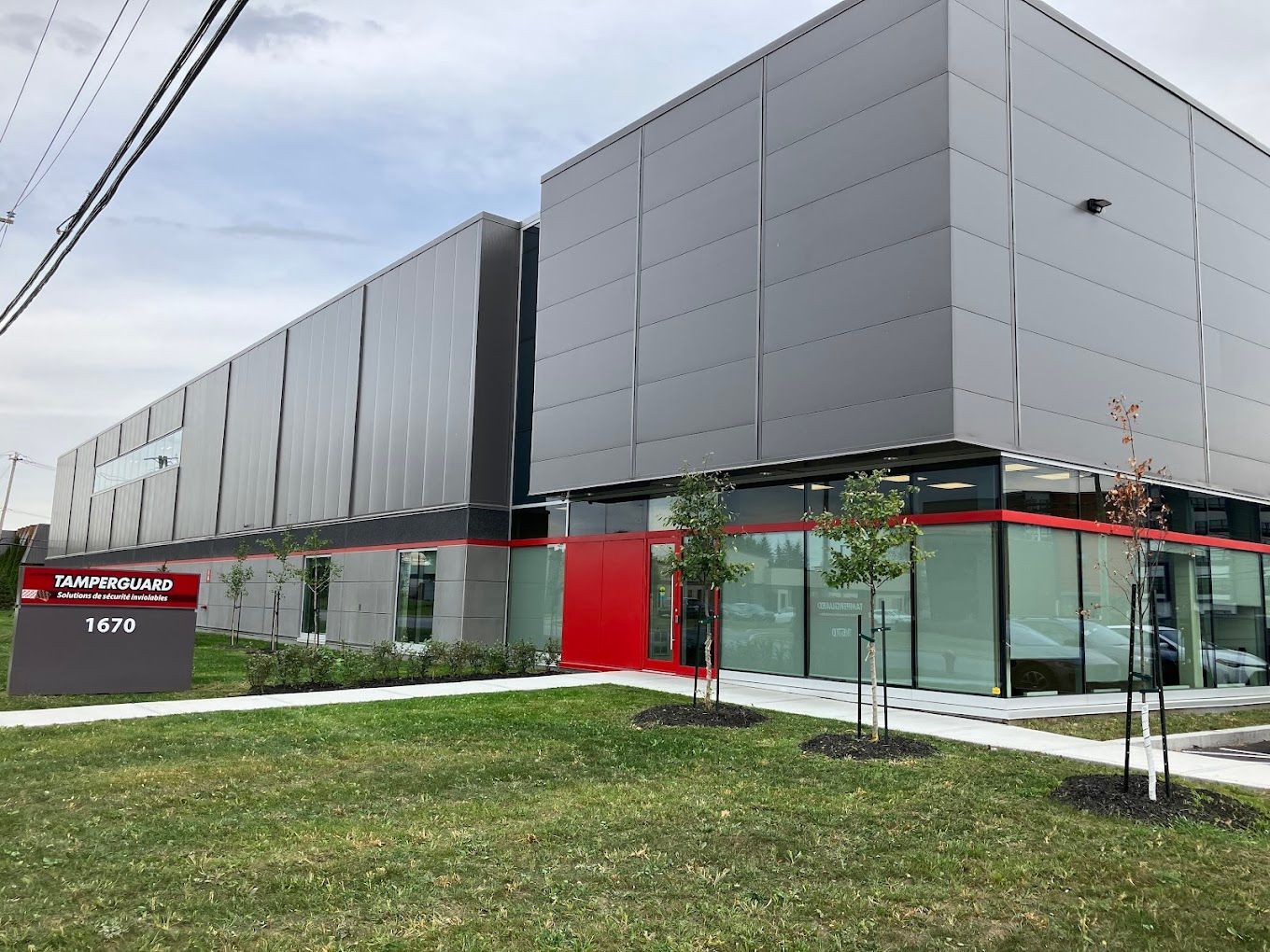 Un grand bâtiment avec beaucoup de fenêtres et une porte rouge.