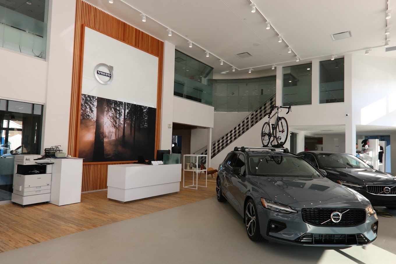 Une voiture Volvo est garée dans une salle d'exposition avec un vélo dessus.