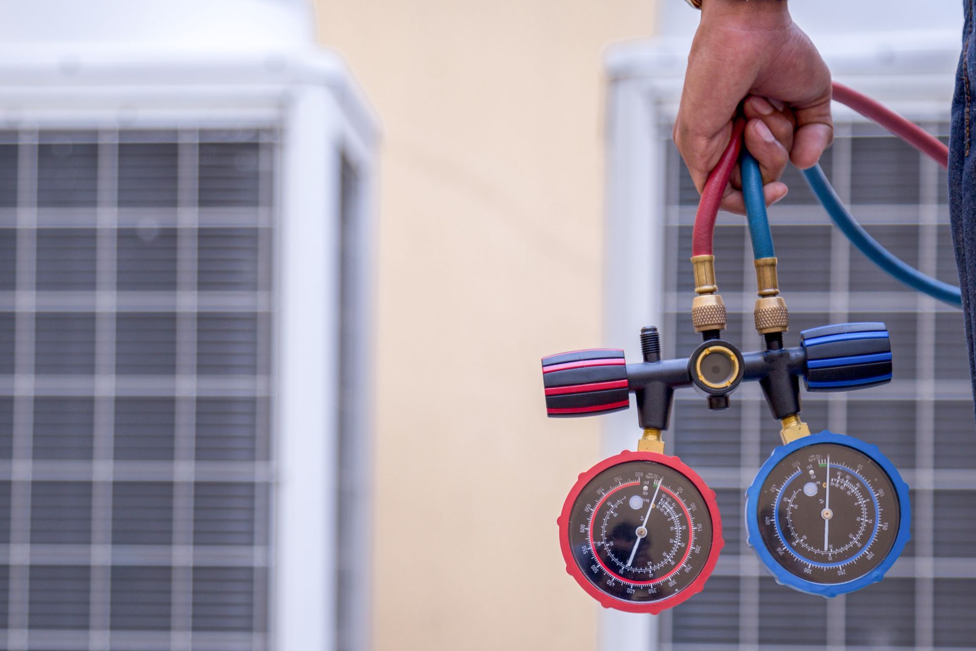 Technician measuring equipment for filling air conditioners during AC repair