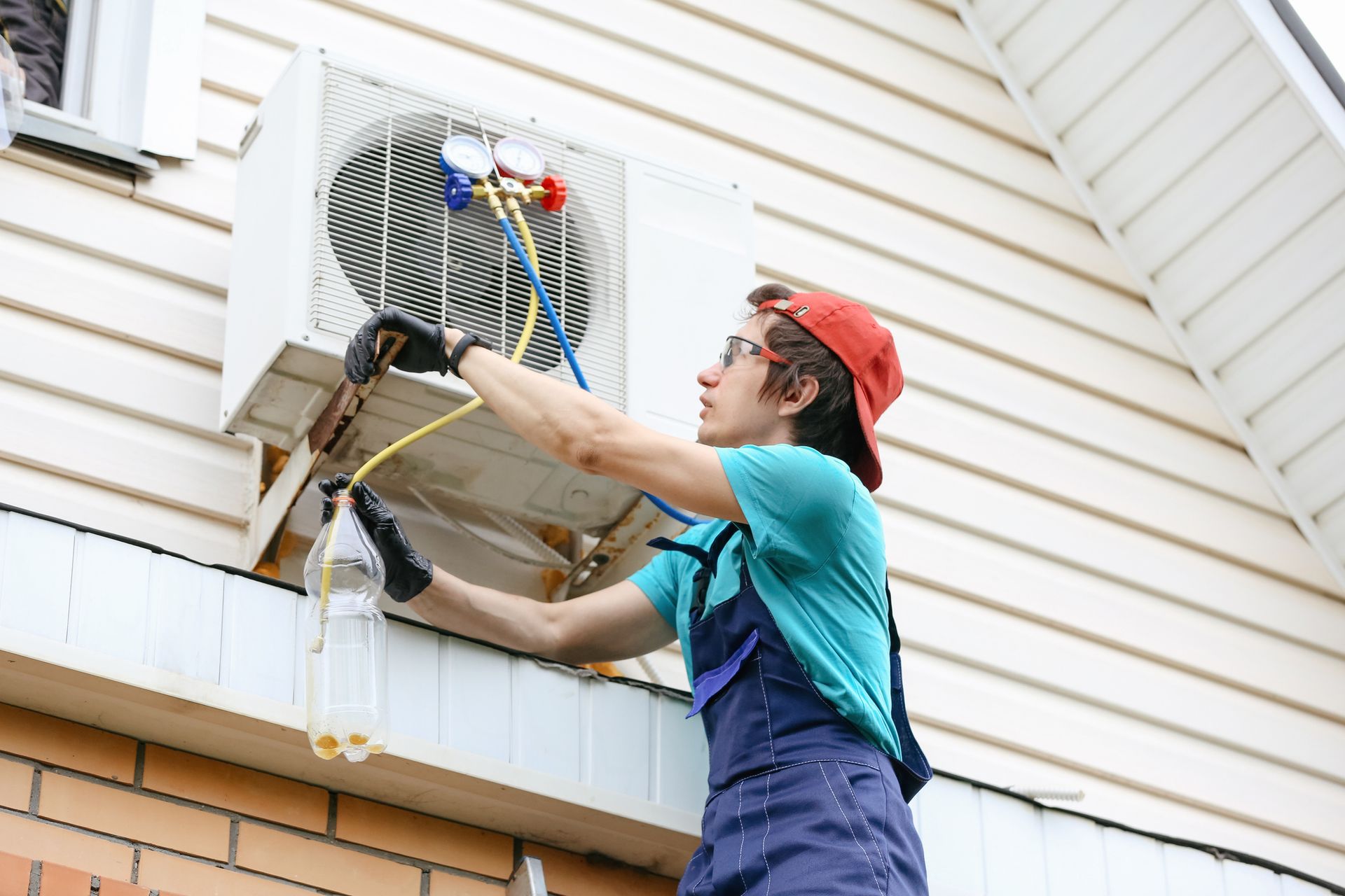 Technician doing home routine, looking at pressure gauge for fixing air conditioner.