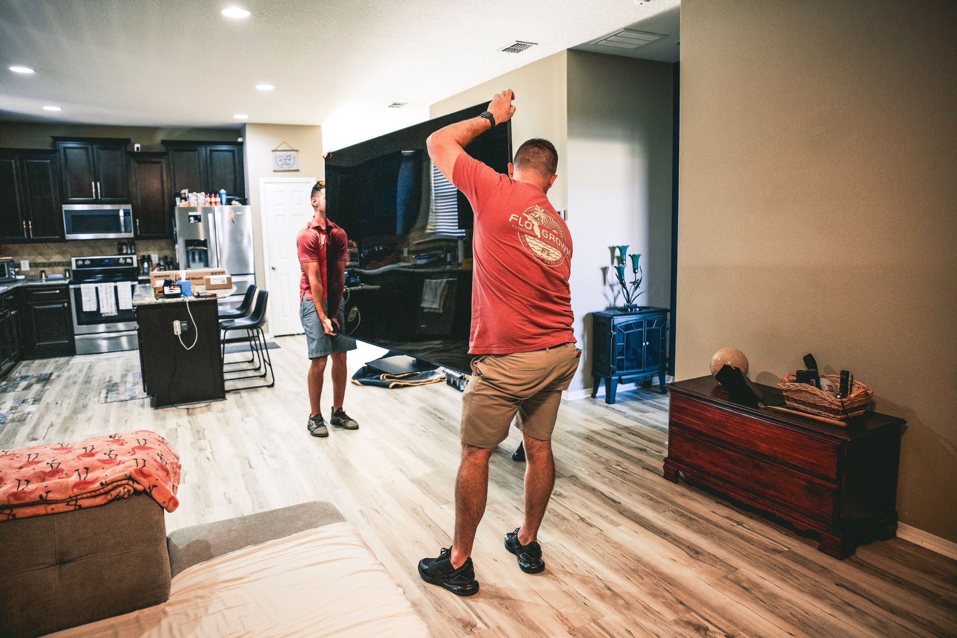 Two men are standing in a living room playing a video game.