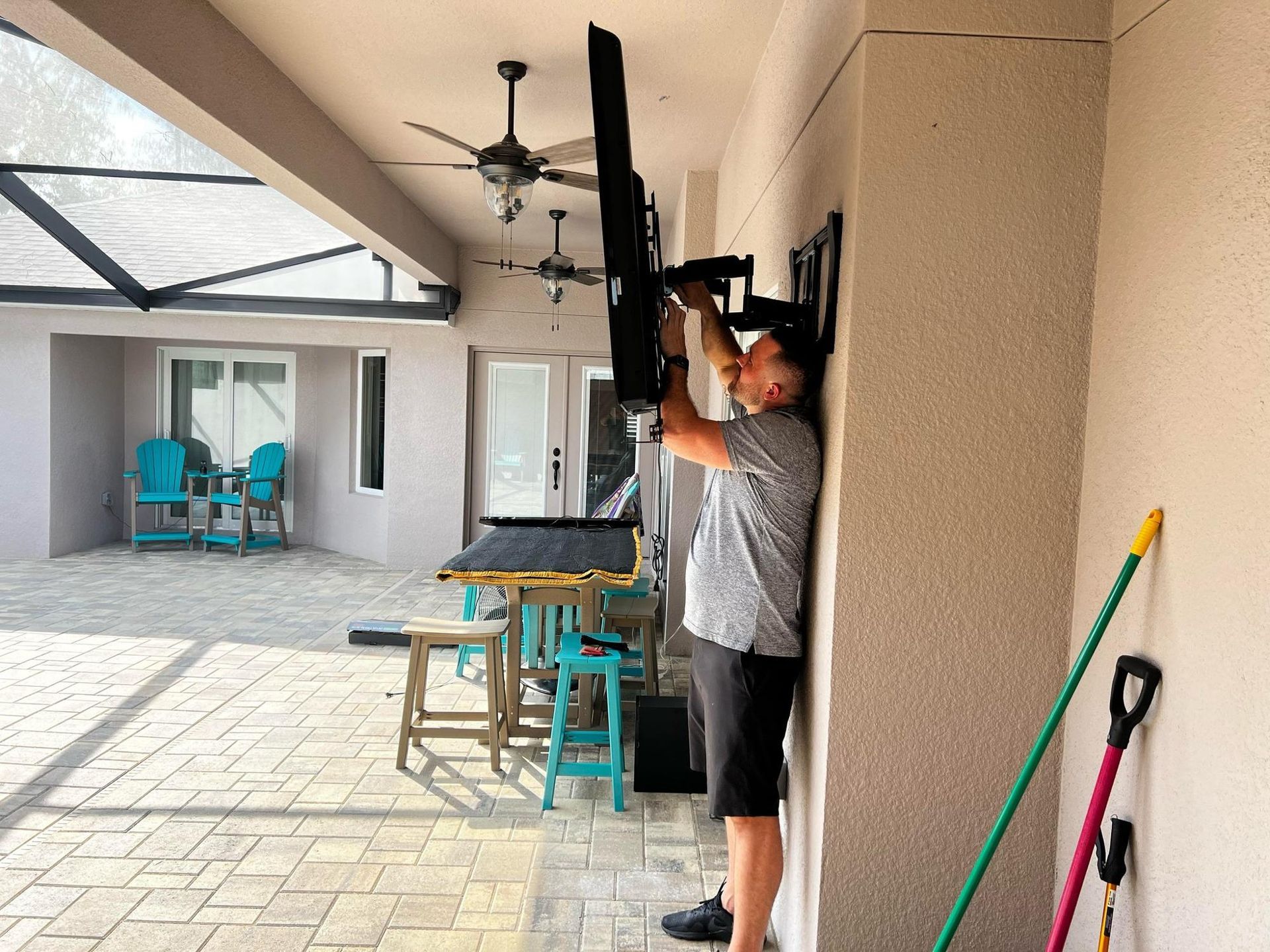 A man is mounting a flat screen tv on a wall.