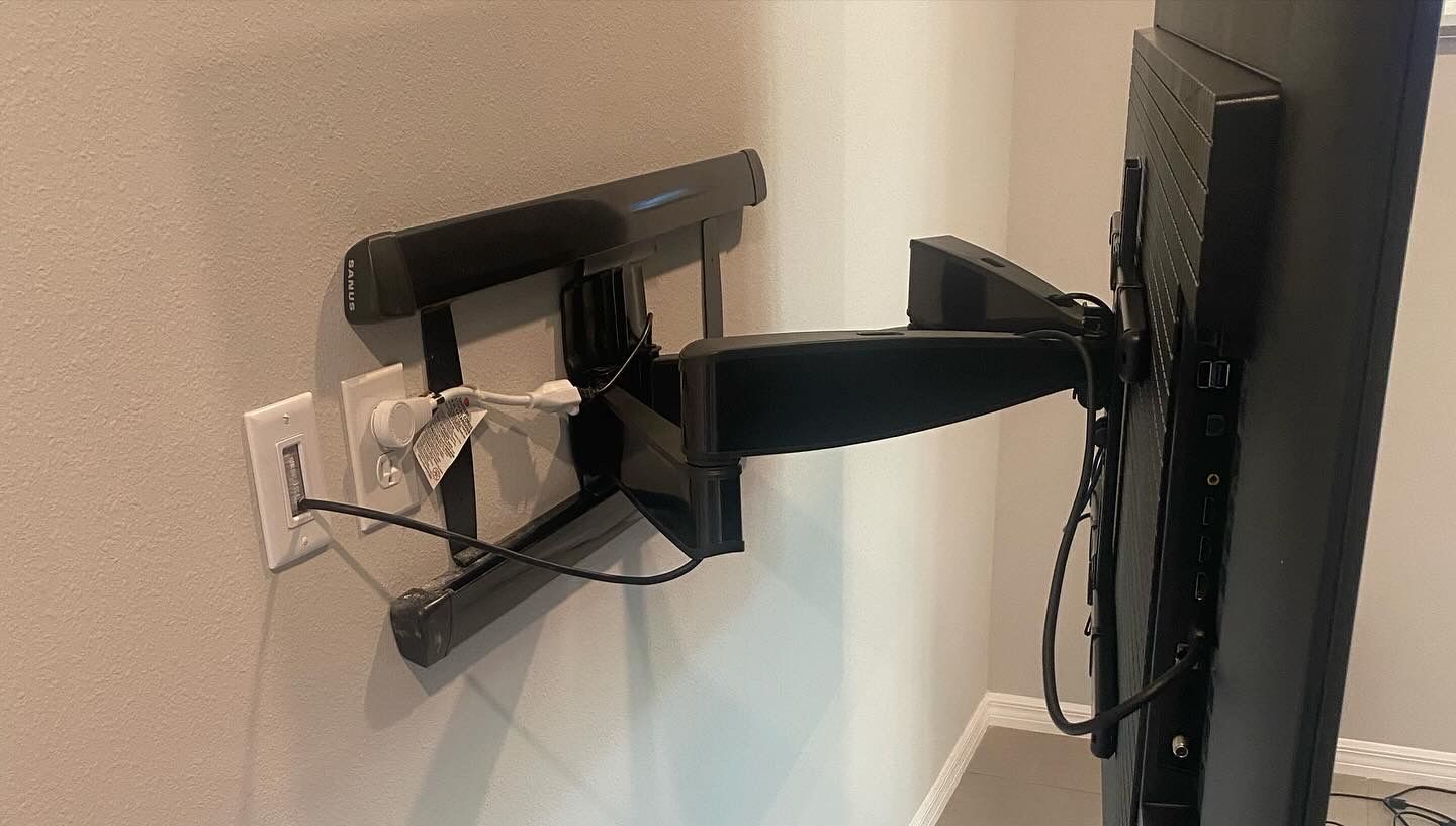A flat screen tv is mounted on a wall with a bracket.