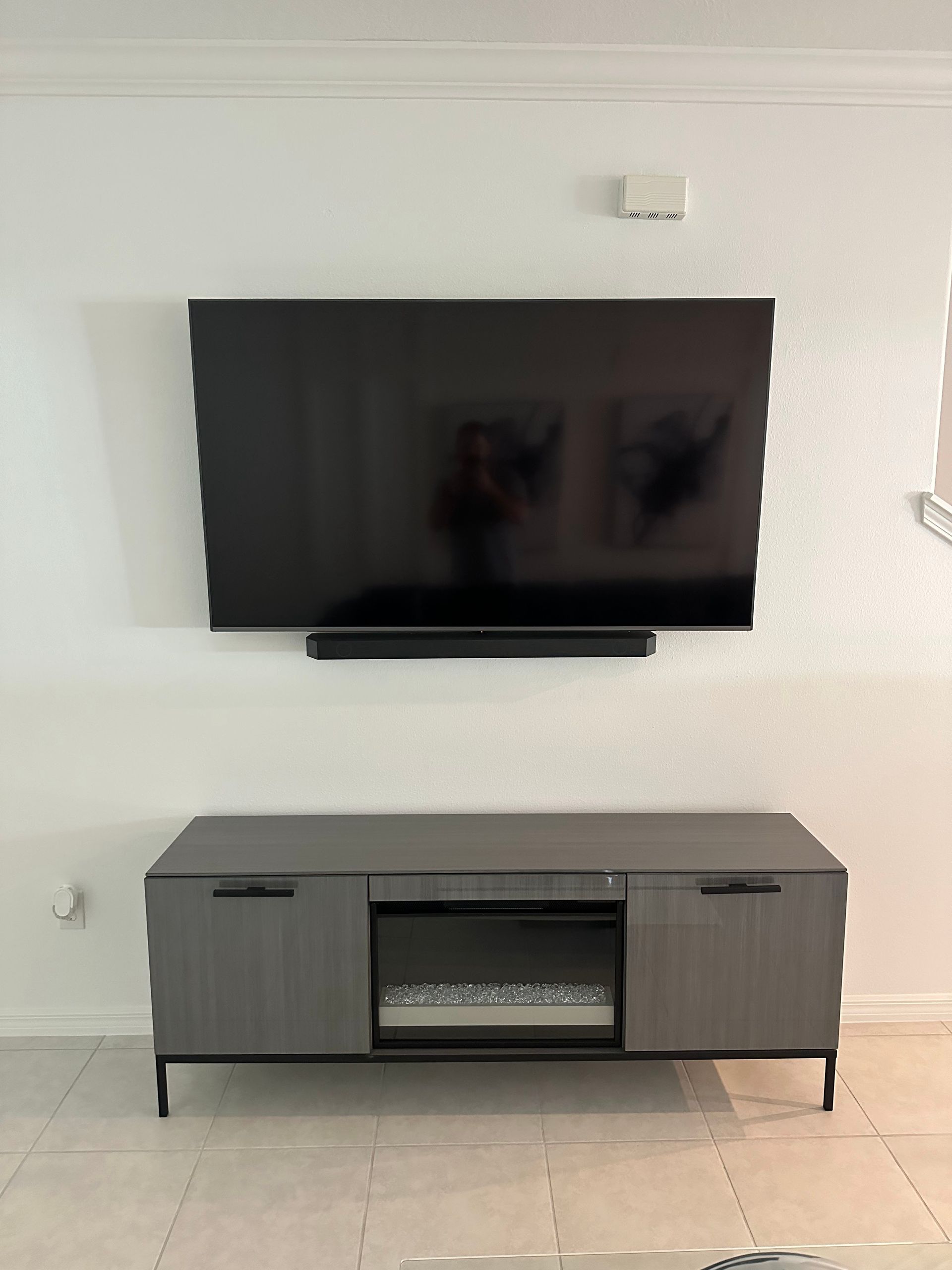 A flat screen tv is mounted on a wall above a fireplace.
