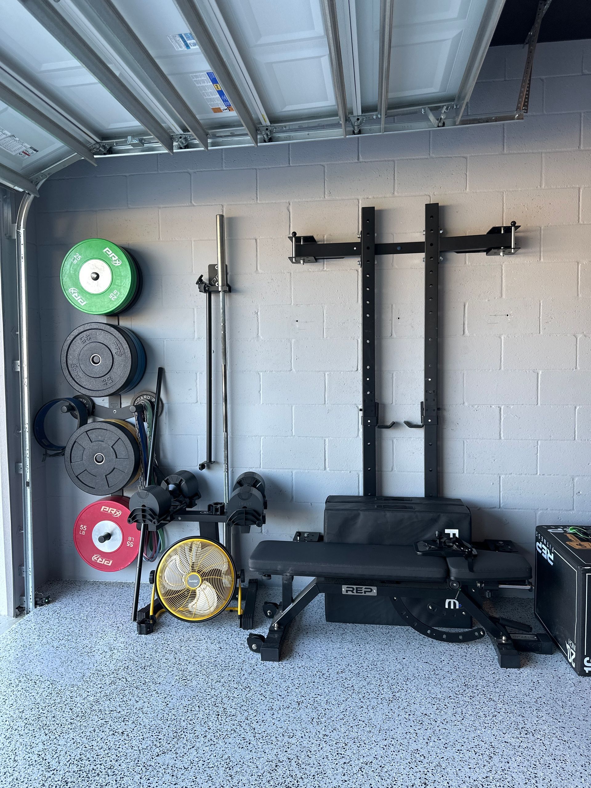 A garage filled with lots of exercise equipment and weights.