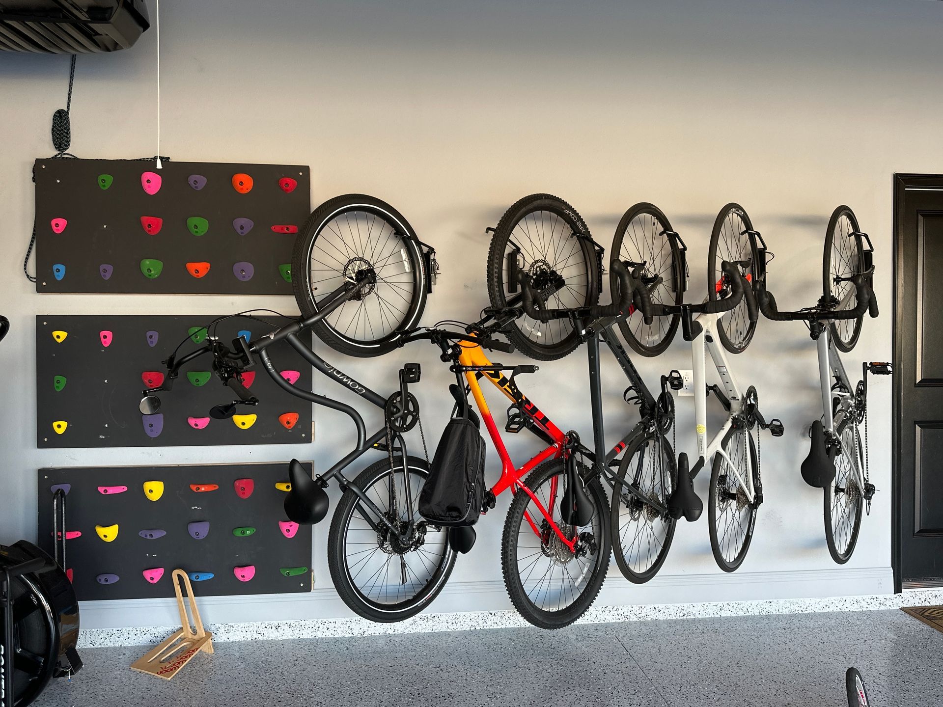 A bunch of bikes are hanging on a wall in a garage.