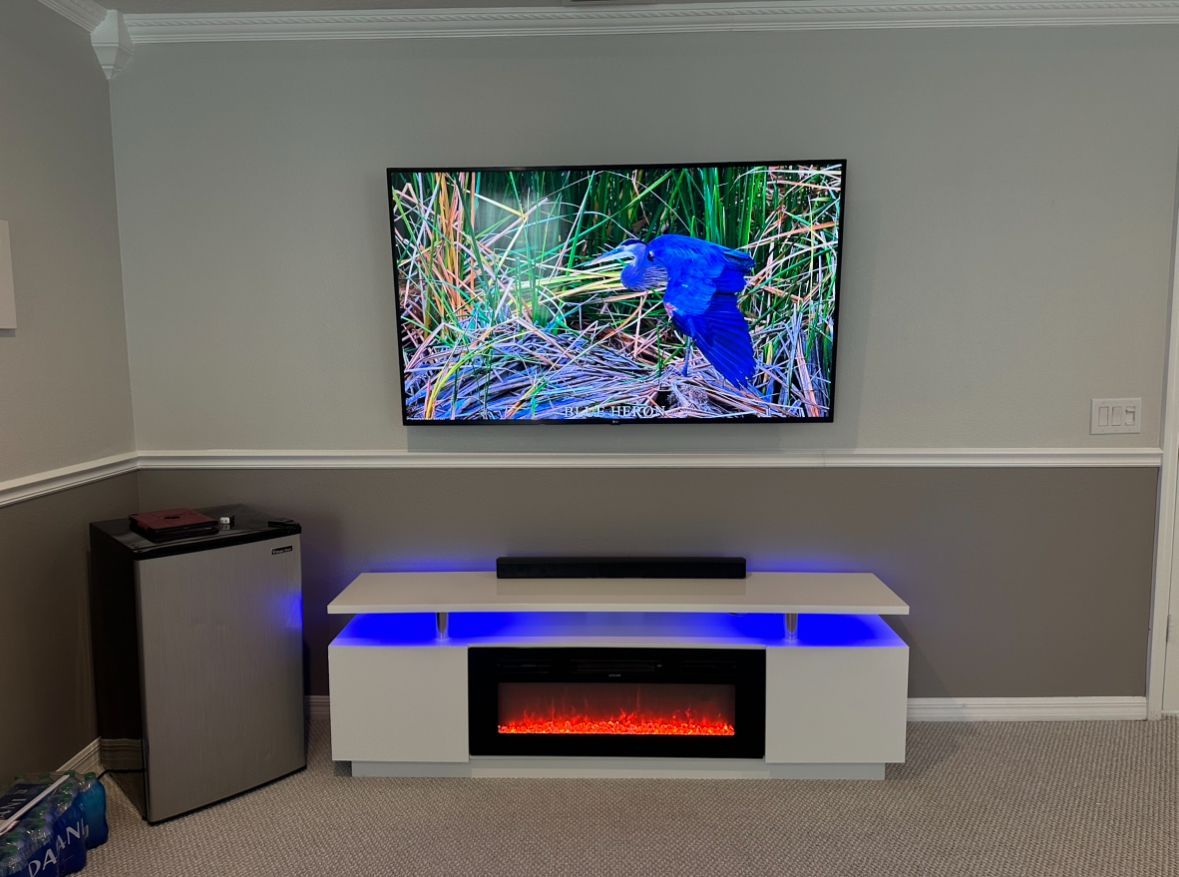 A living room with a flat screen tv and a fireplace.