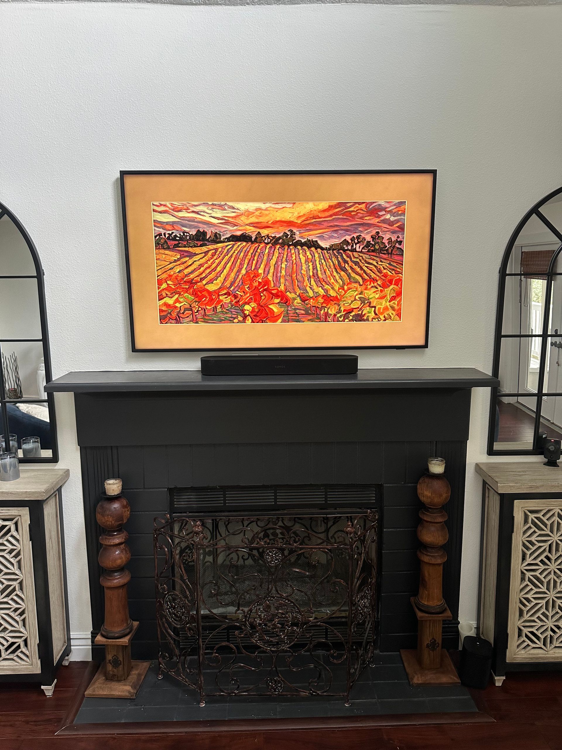 A living room with a fireplace and a painting on the wall above it