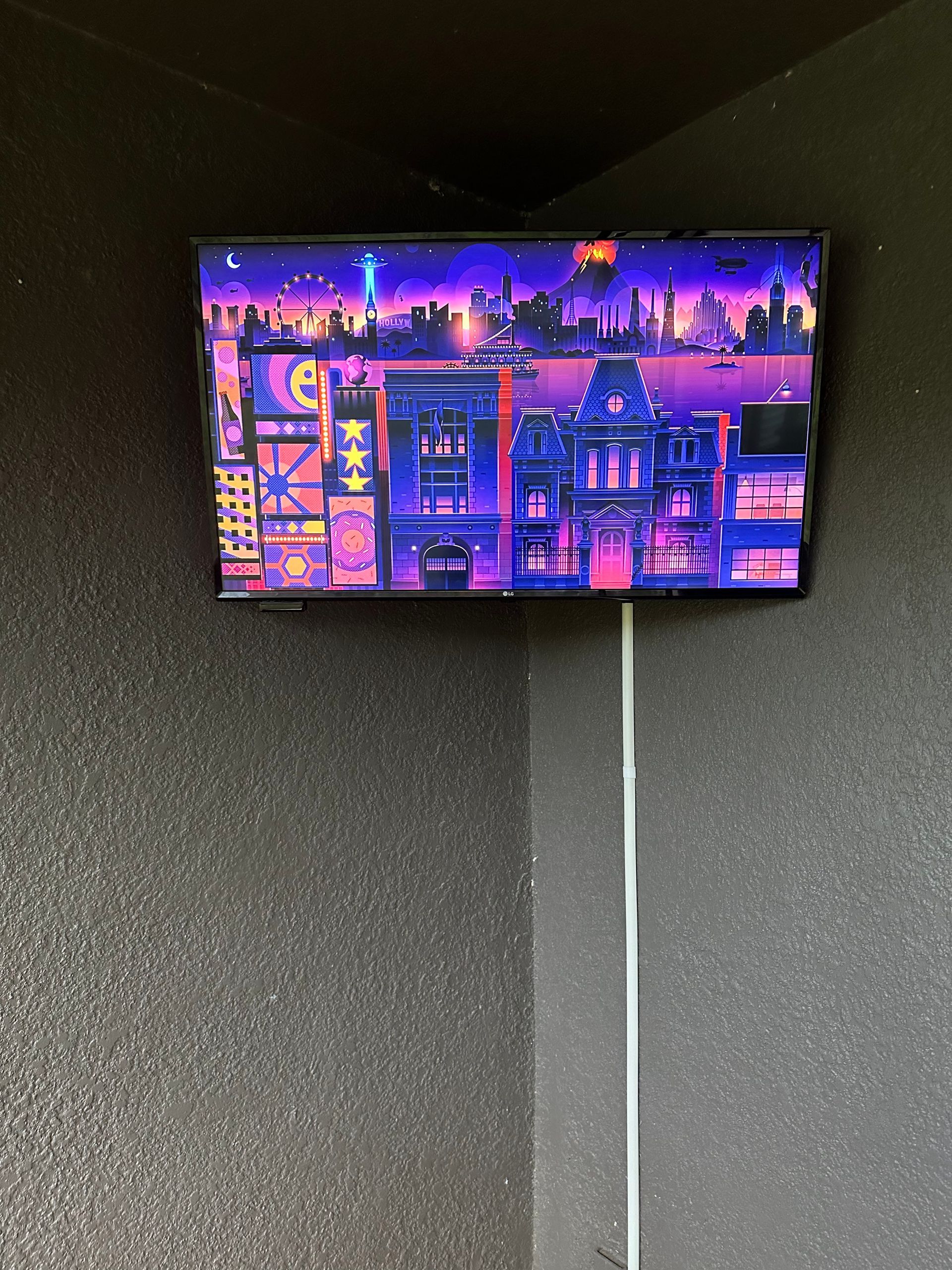 A television hanging on a wall with a picture of a city on the screen