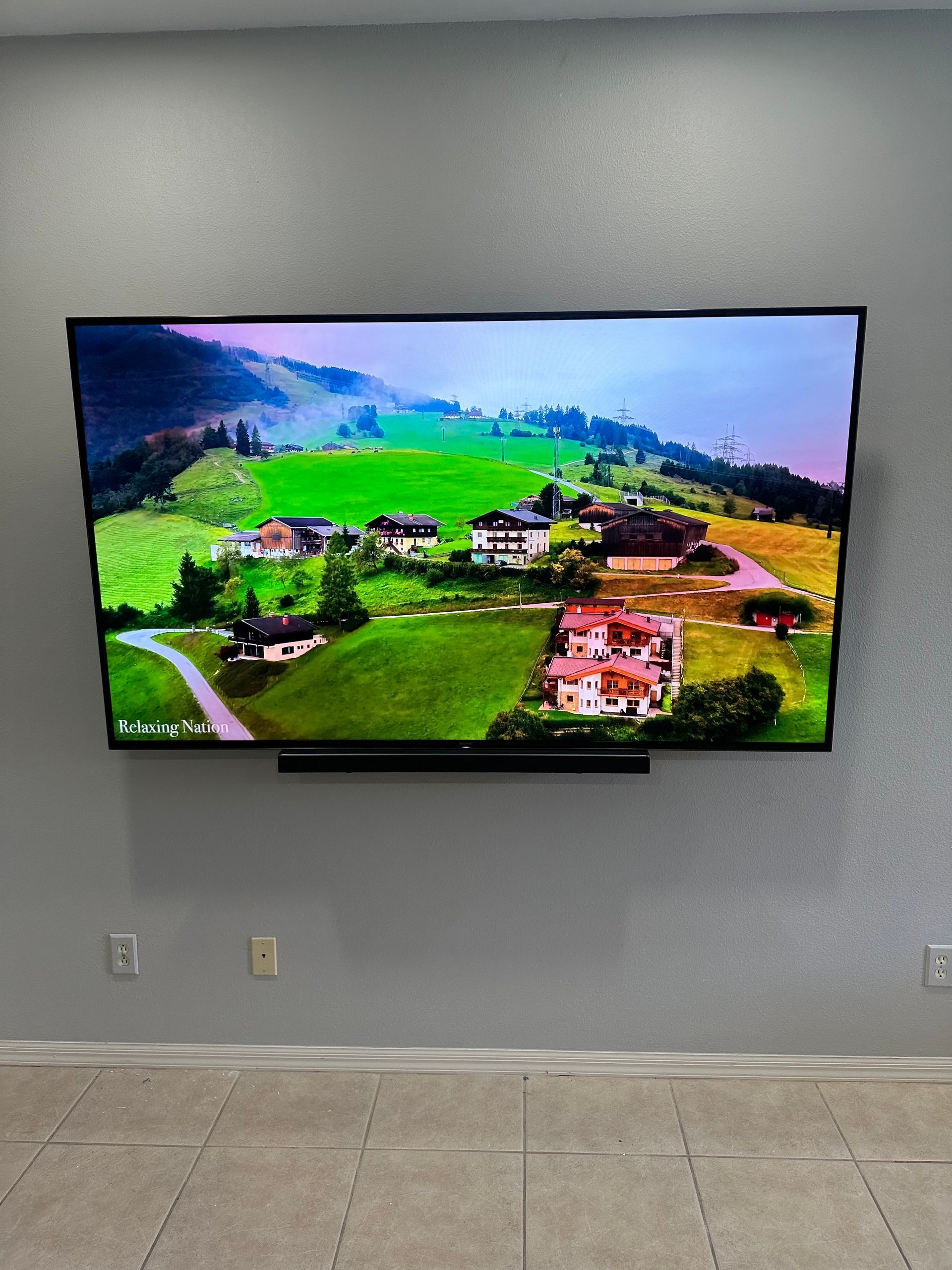 A large flat screen tv is hanging on a wall in a living room.