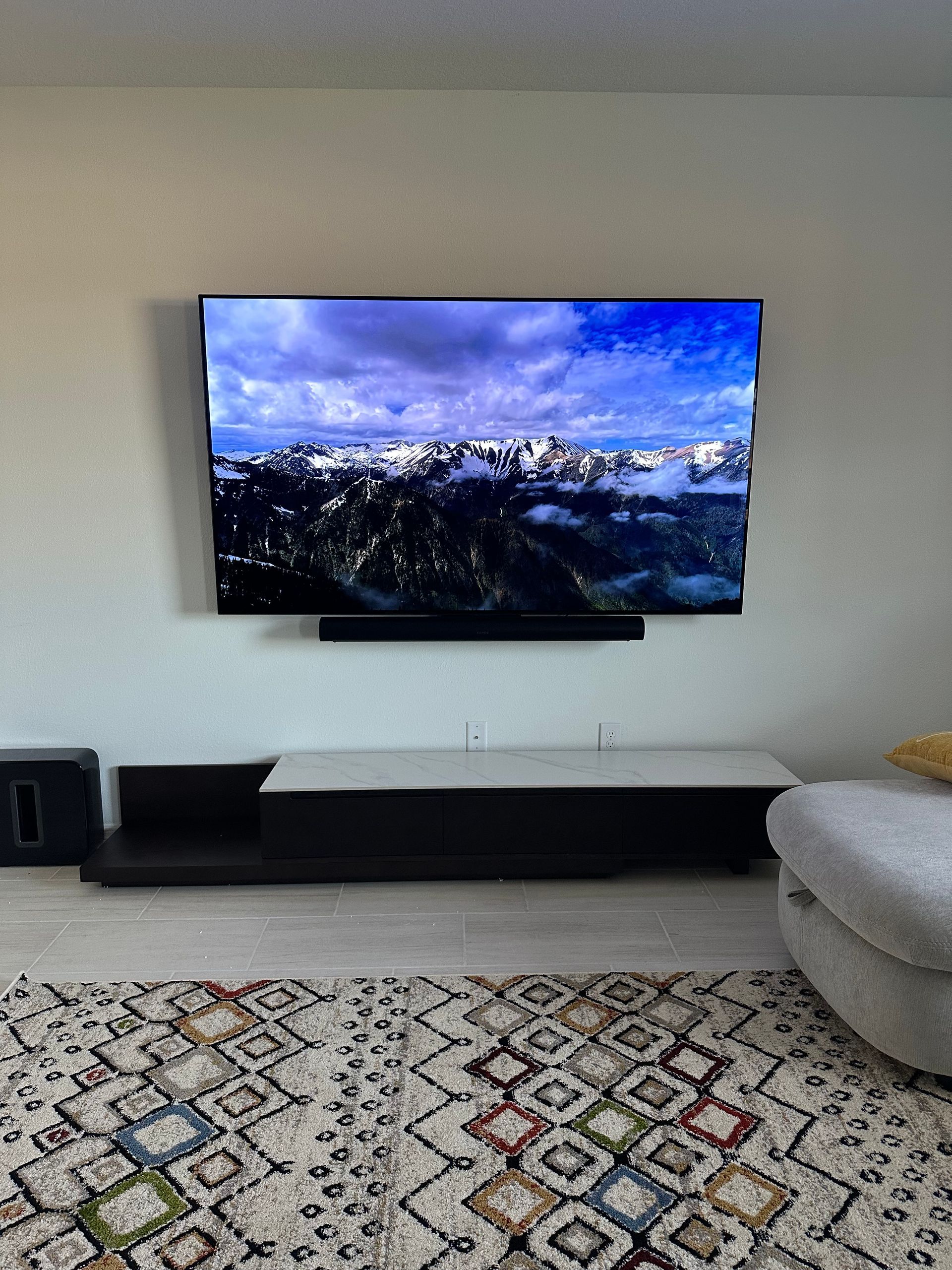 A flat screen tv is mounted on a wall in a living room.