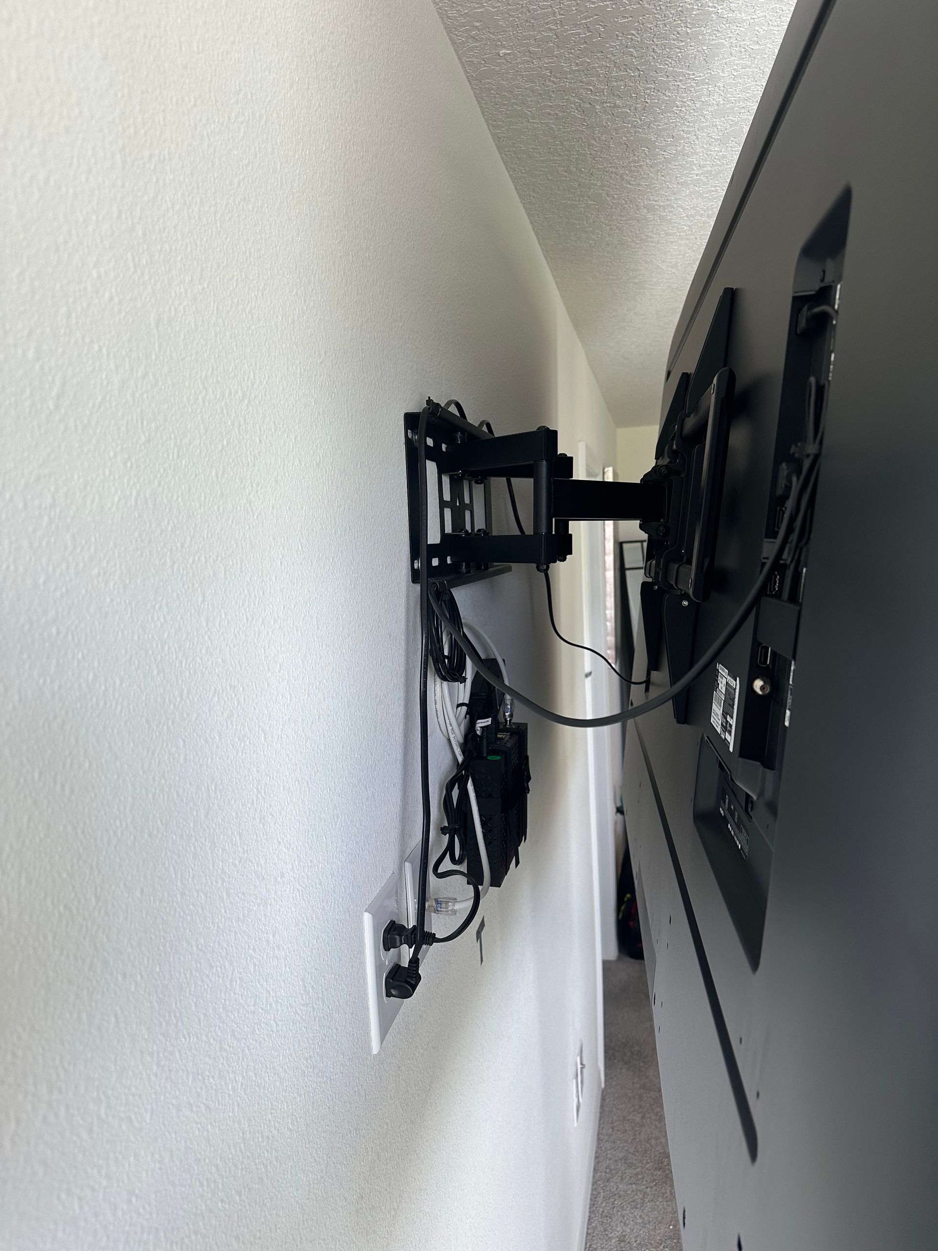 A flat screen tv is mounted on a wall in a hallway.