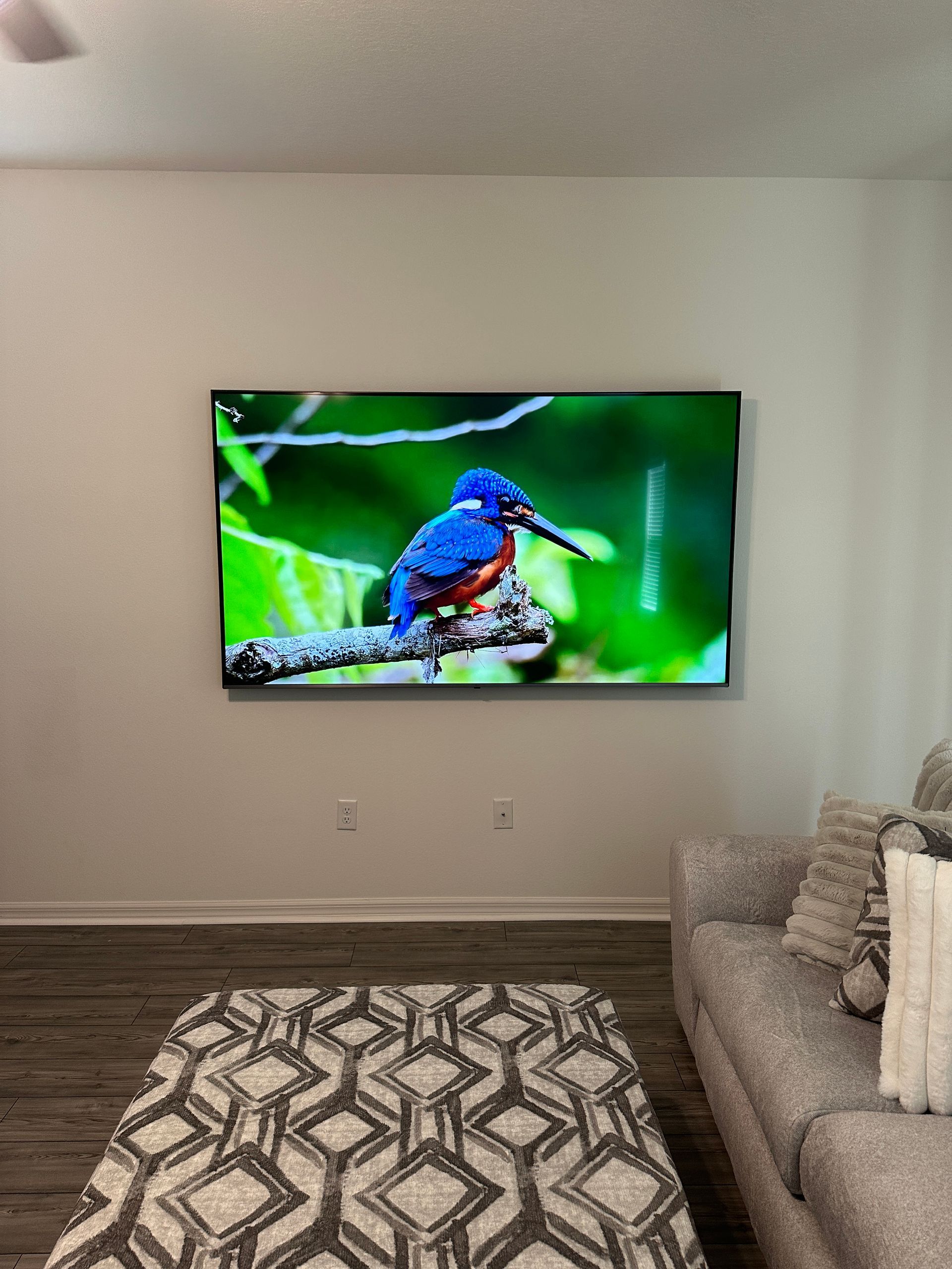 A living room with a large flat screen tv hanging on the wall.