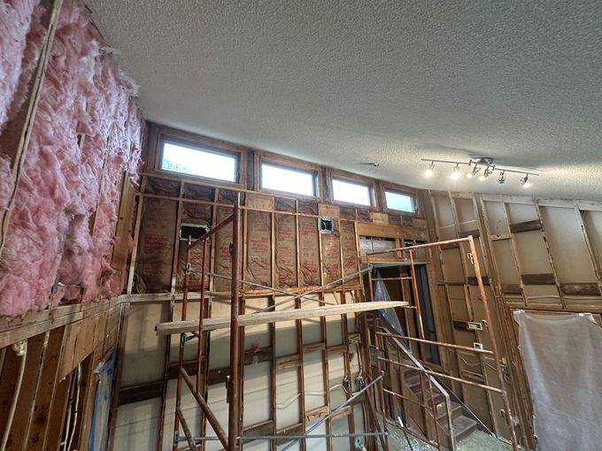 A room with a lot of wooden walls and a ceiling that is being remodeled.