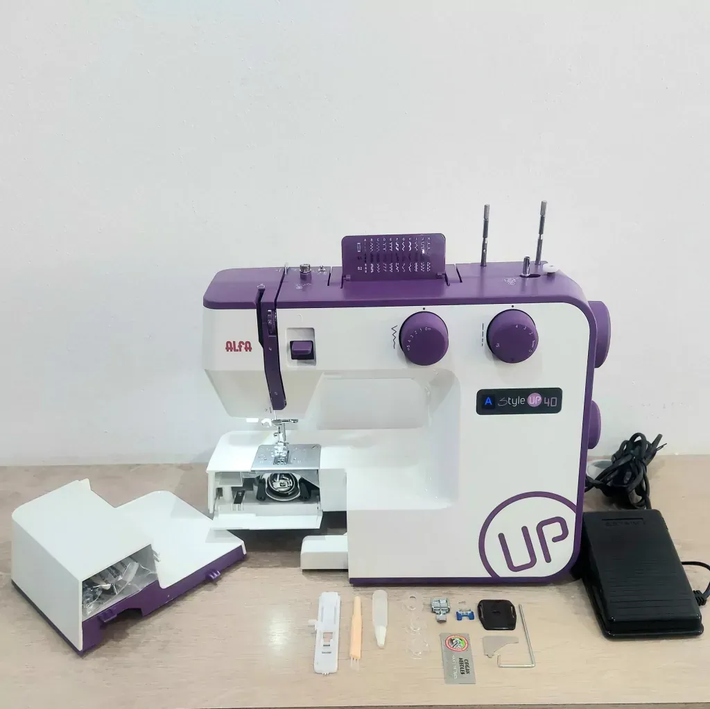 Máquina de coser blanca y morada en un estante. Marca