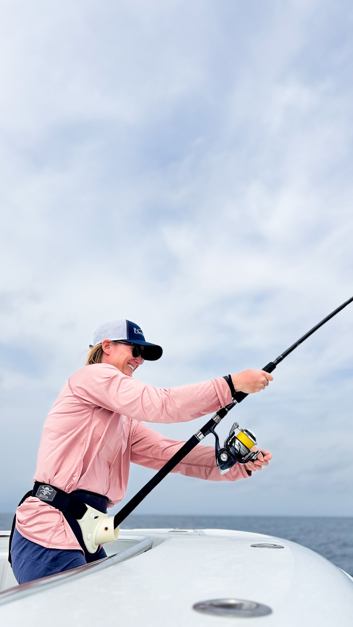 A man is fishing on a boat in the ocean.