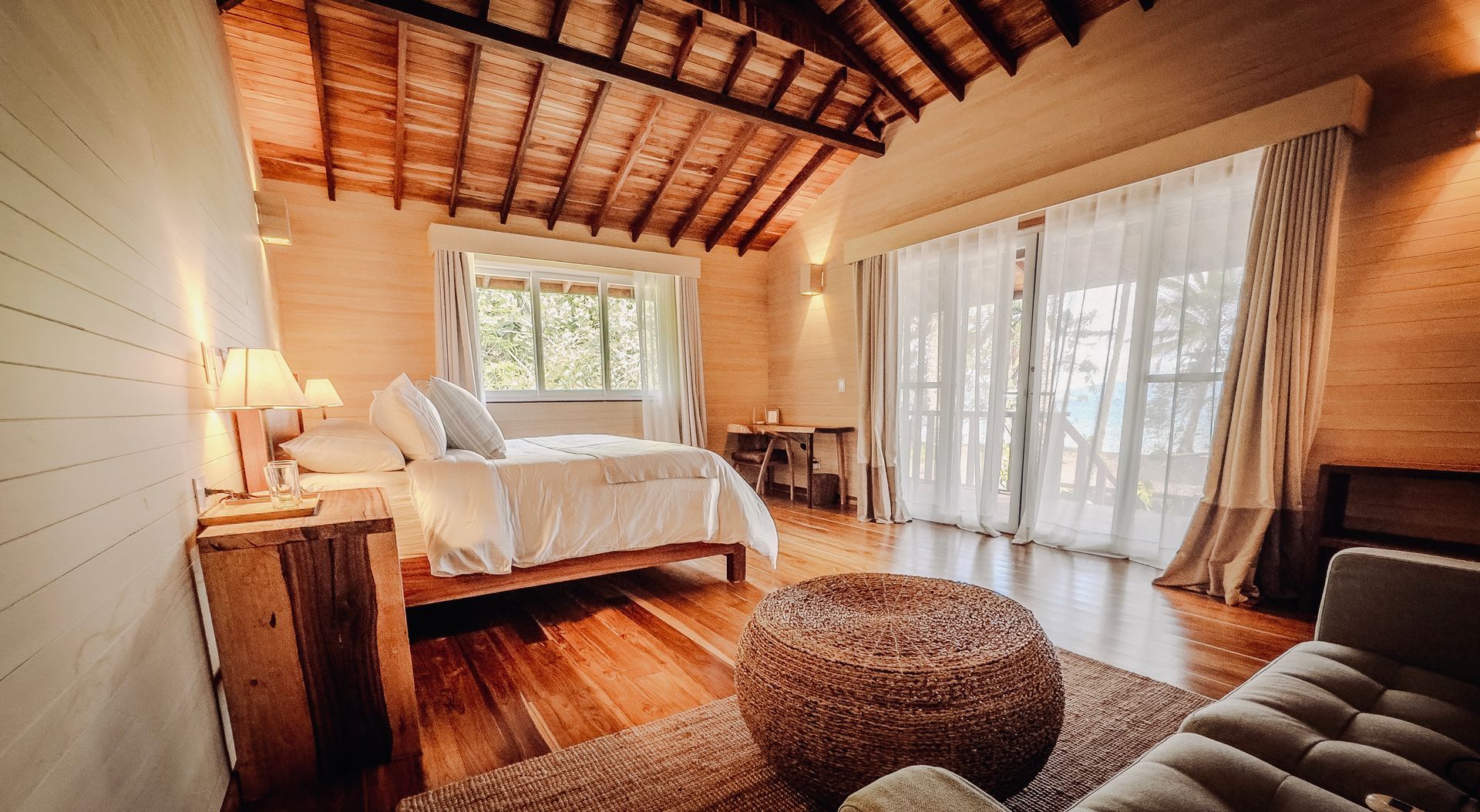 A hotel room with two beds , lamps and a wooden floor.