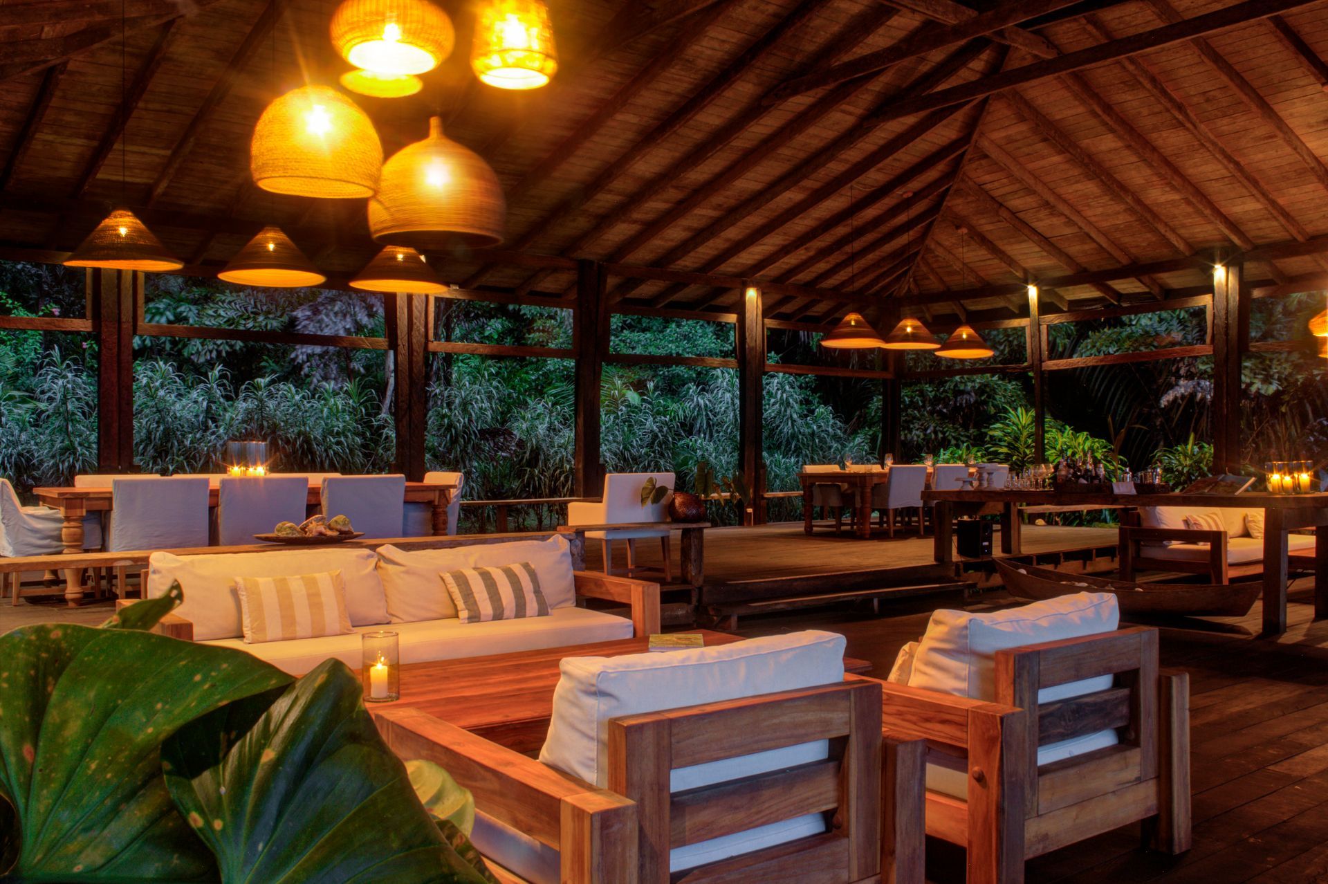 A living room with a lot of furniture and a thatched roof.