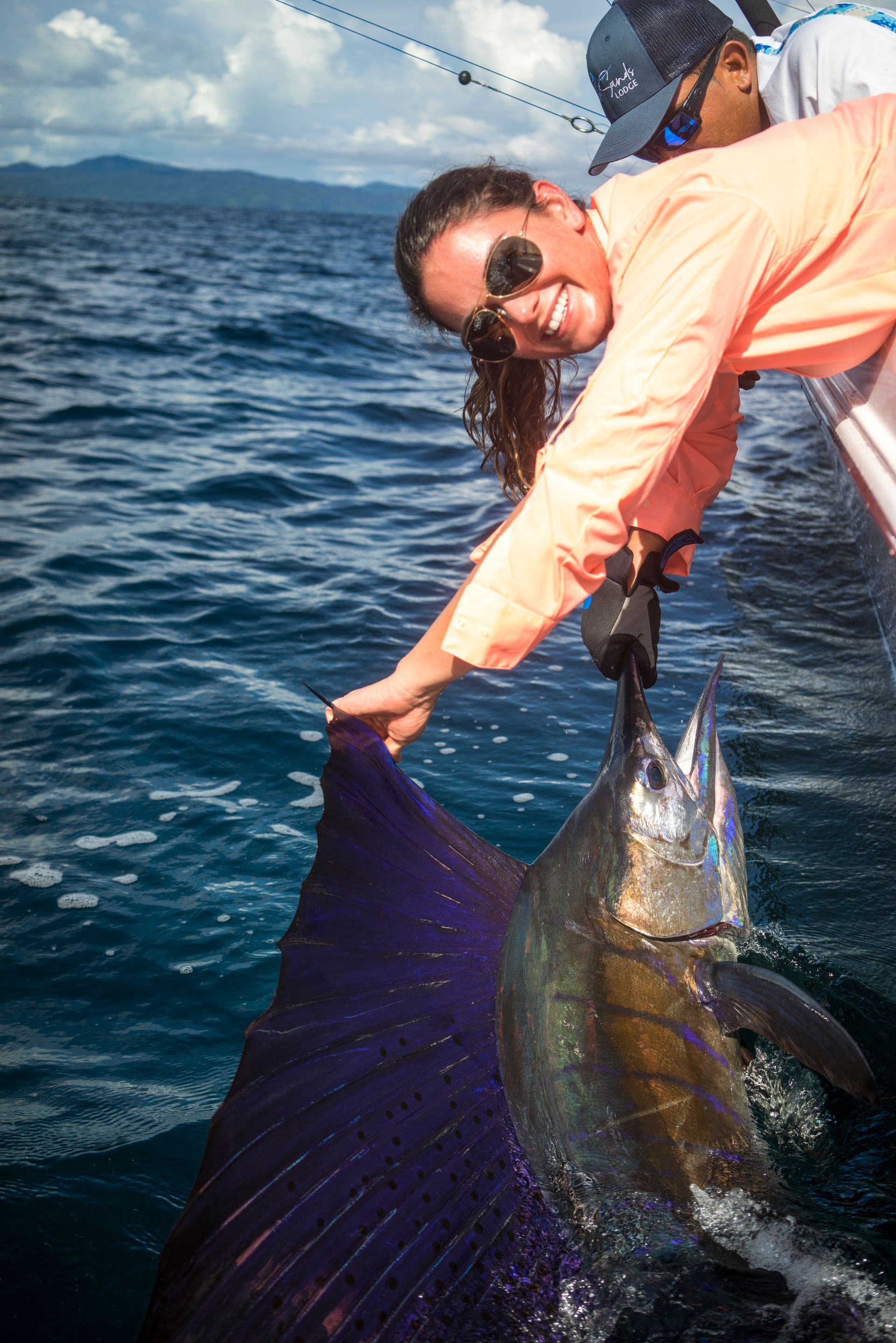 A group of people are fishing on a boat in the ocean.