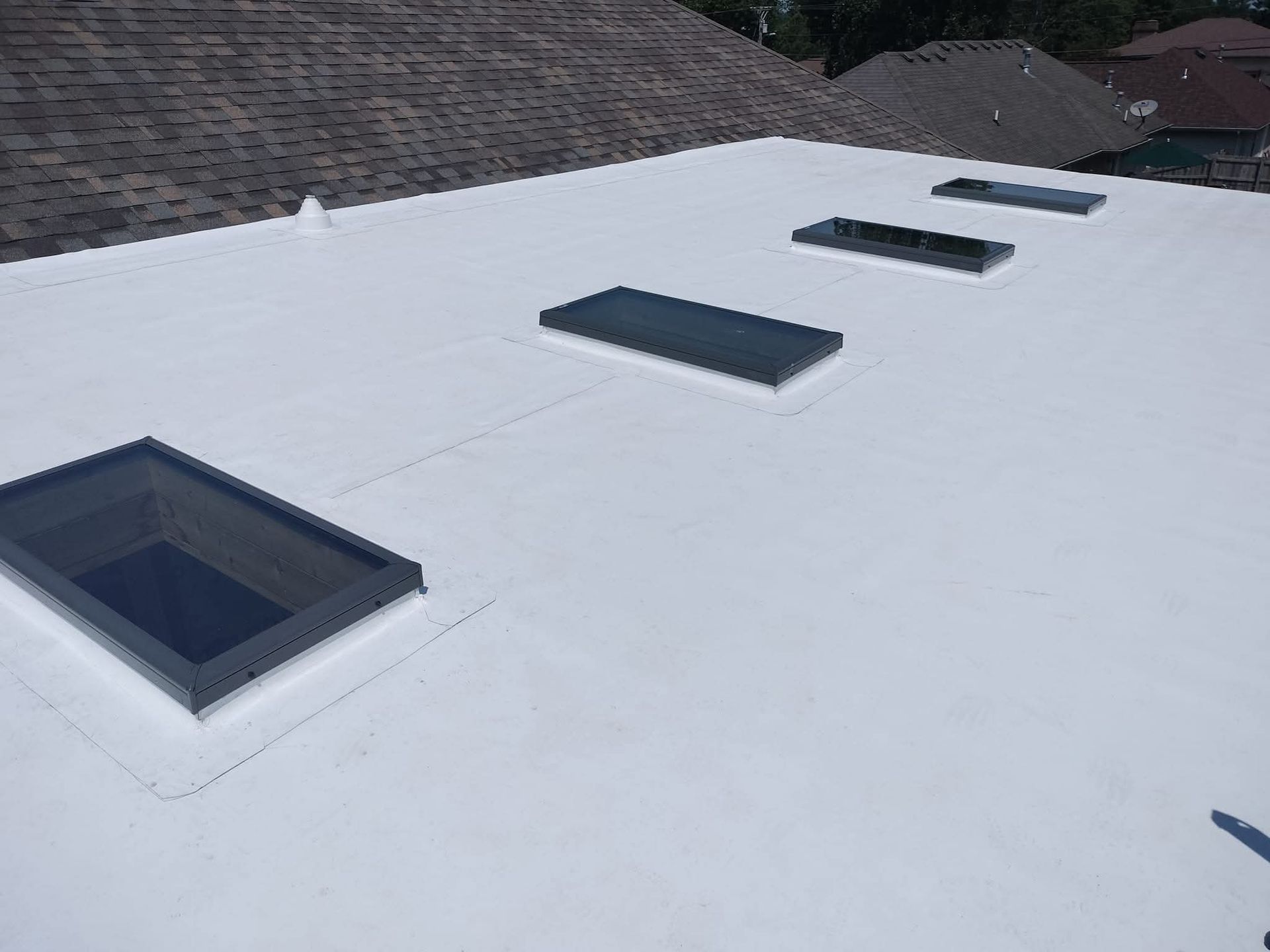 White flat roof with four skylights.