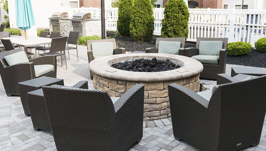 a fire pit surrounded by chairs and tables