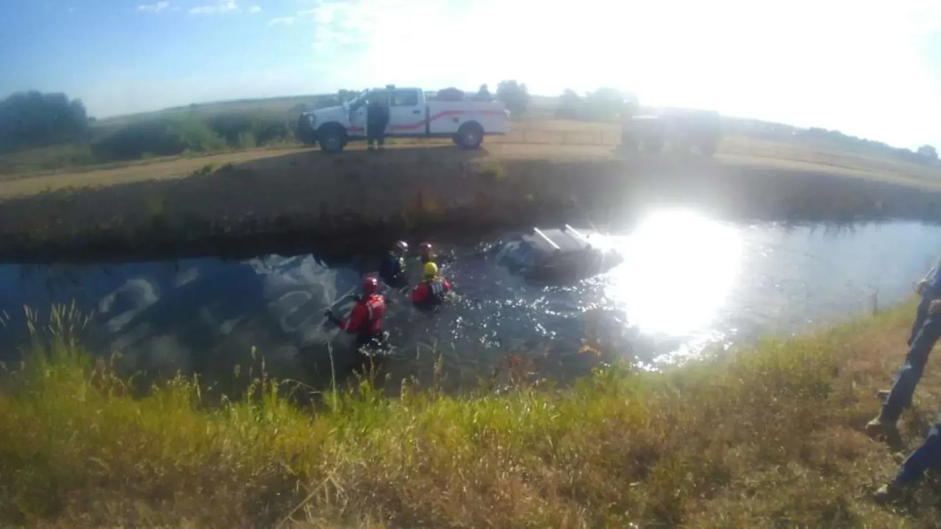 A group of people are standing in a body of water.