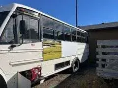 A white bus is parked in front of a house.