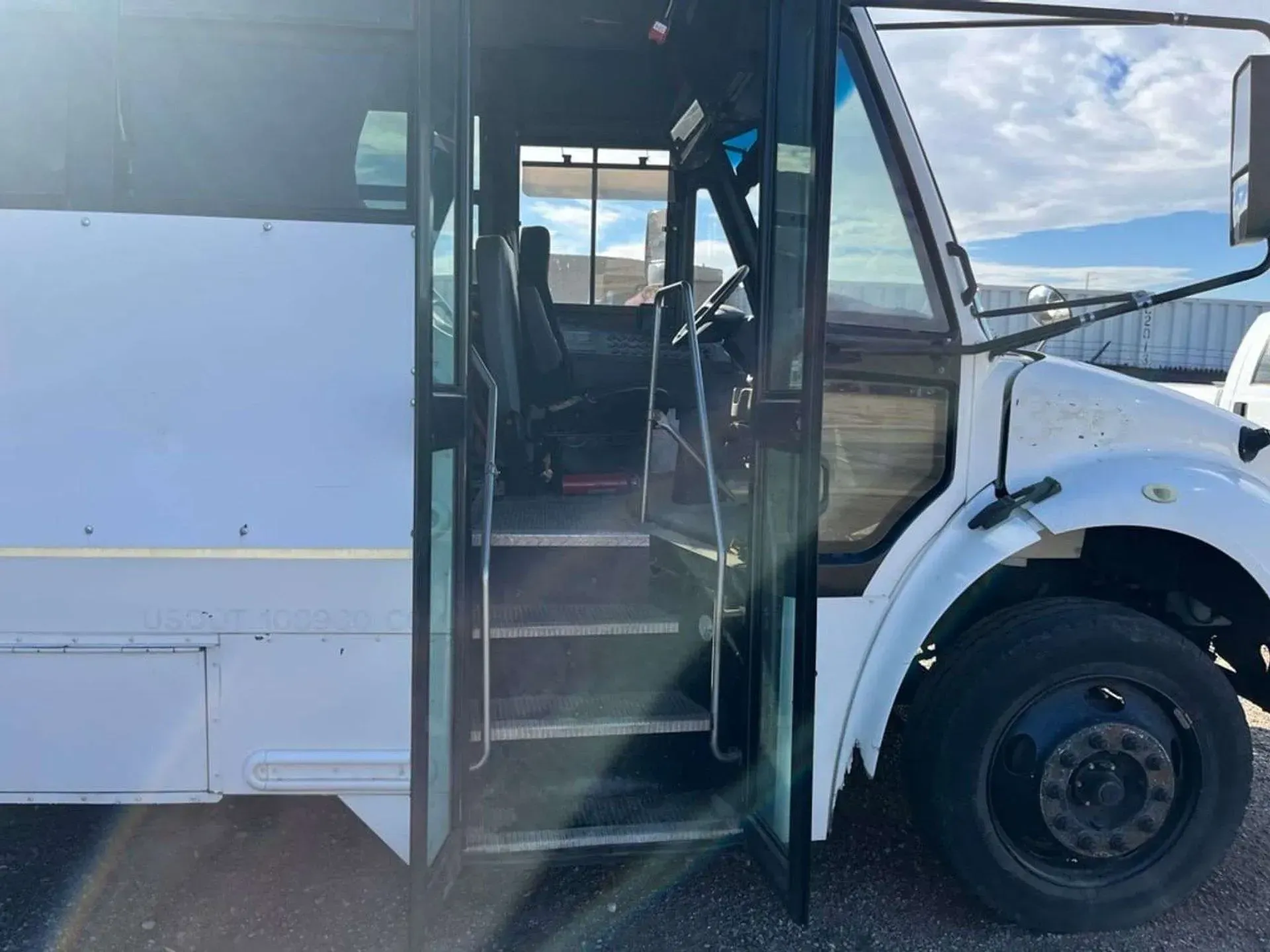 A white bus with the door open and the stairs visible.