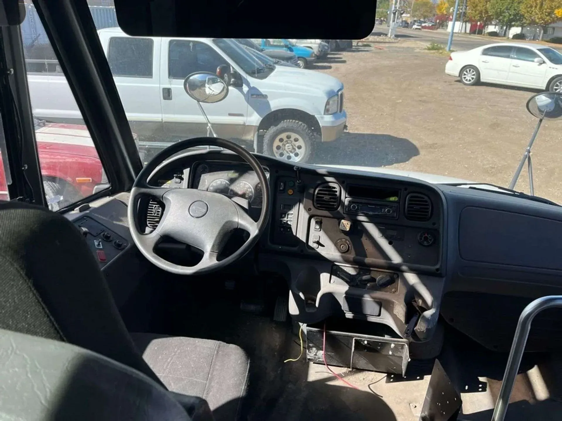 The inside of a bus with a steering wheel and seats