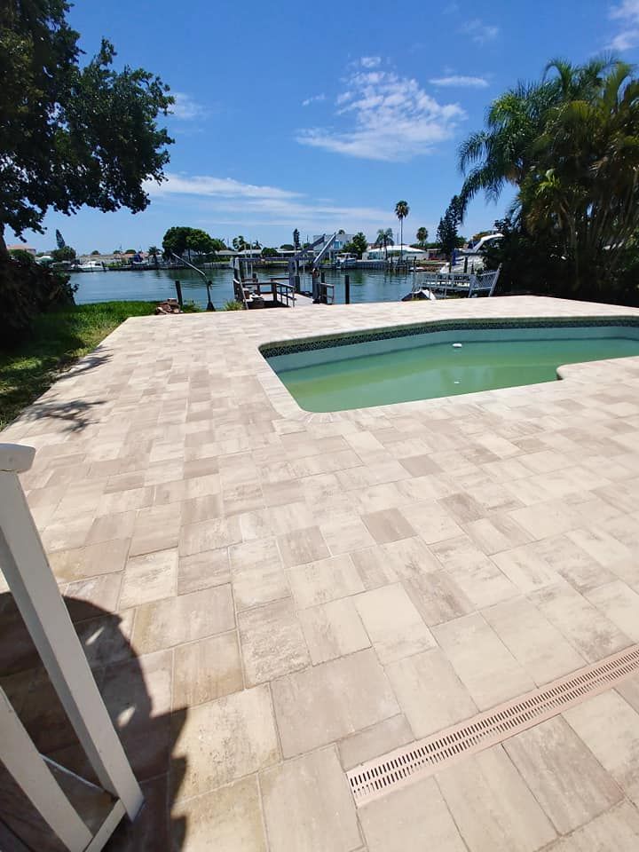 Poolside patio overlooking a waterfront dock and boats under a sunny blue sky