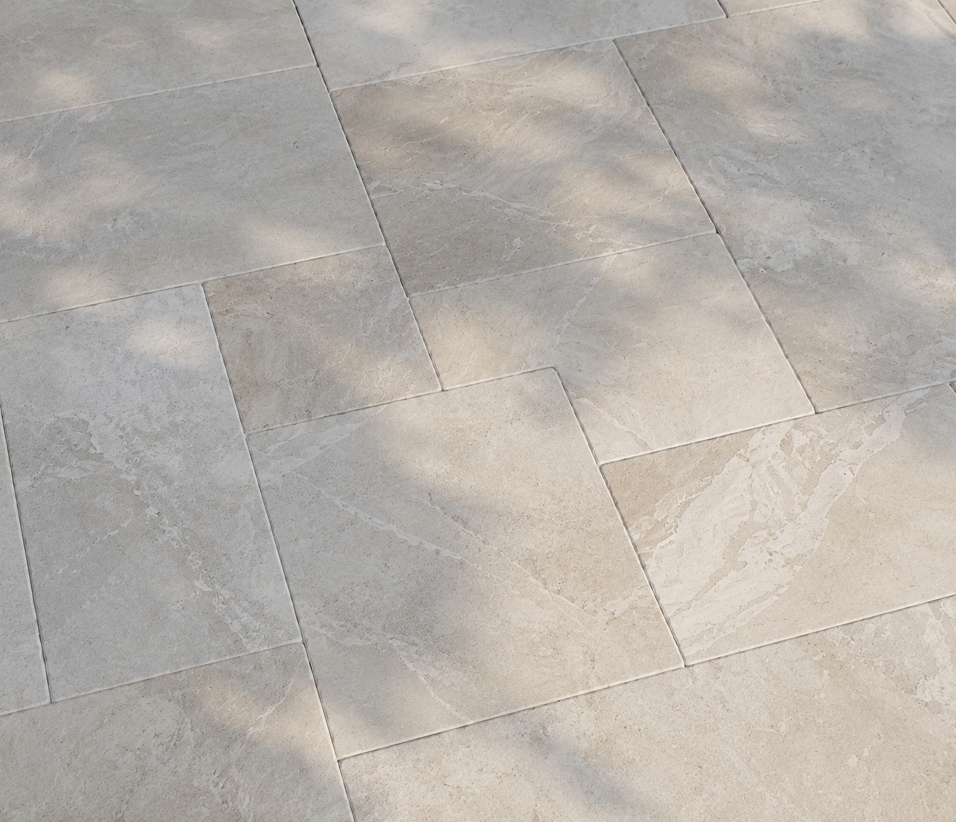 Close-up of light beige stone floor tiles with subtle gray veining and grout lines