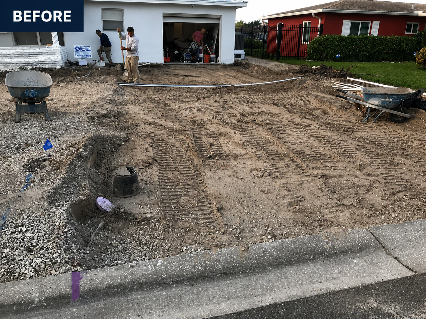 Before view of a house with a torn-up front yard and workers in the driveway