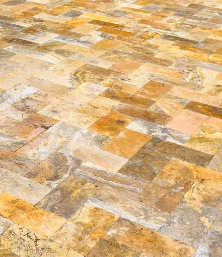 Mosaic stone patio with tan, gray, and gold tiles in a geometric pattern