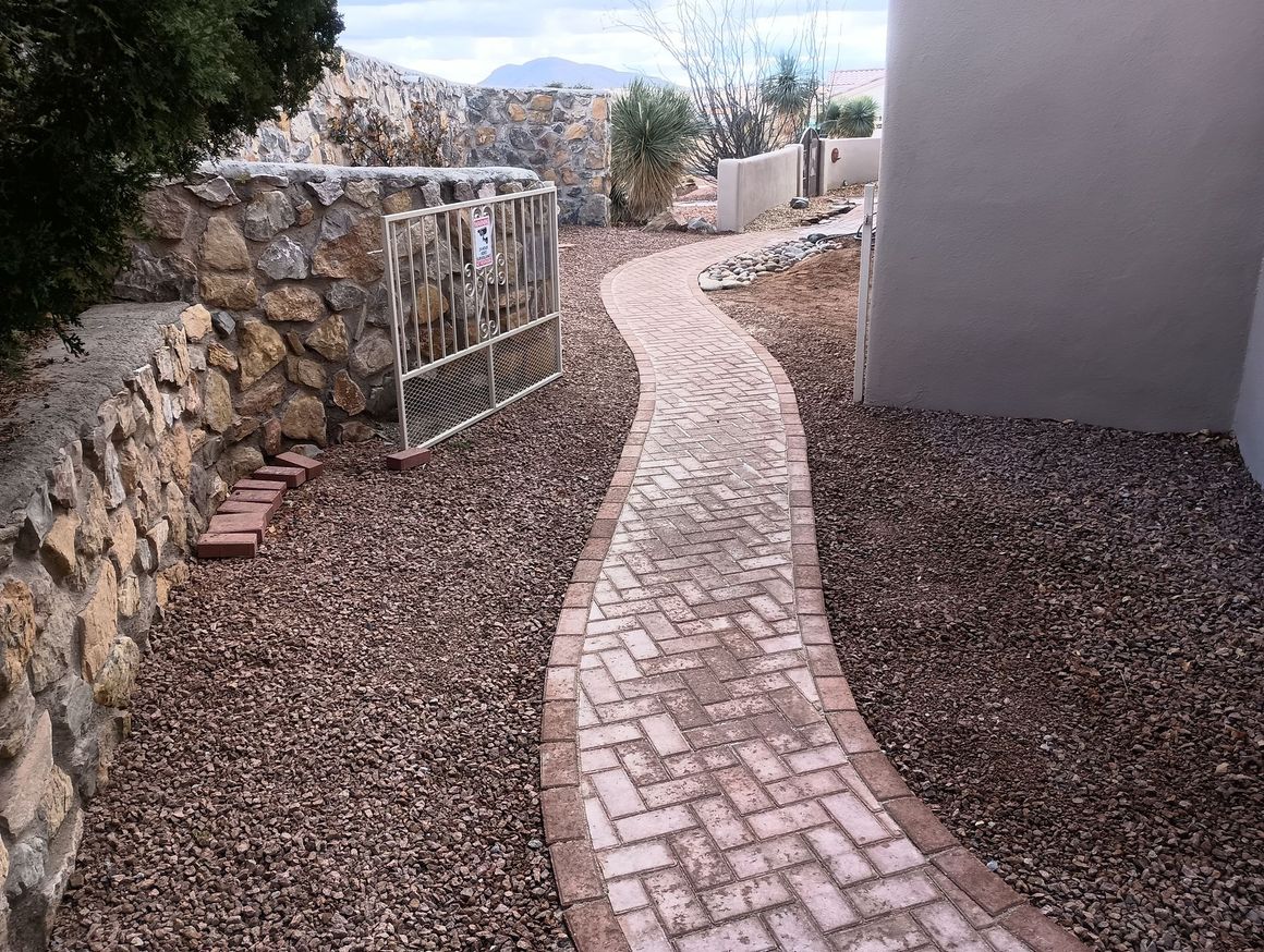 A brick walkway leading to a stone wall