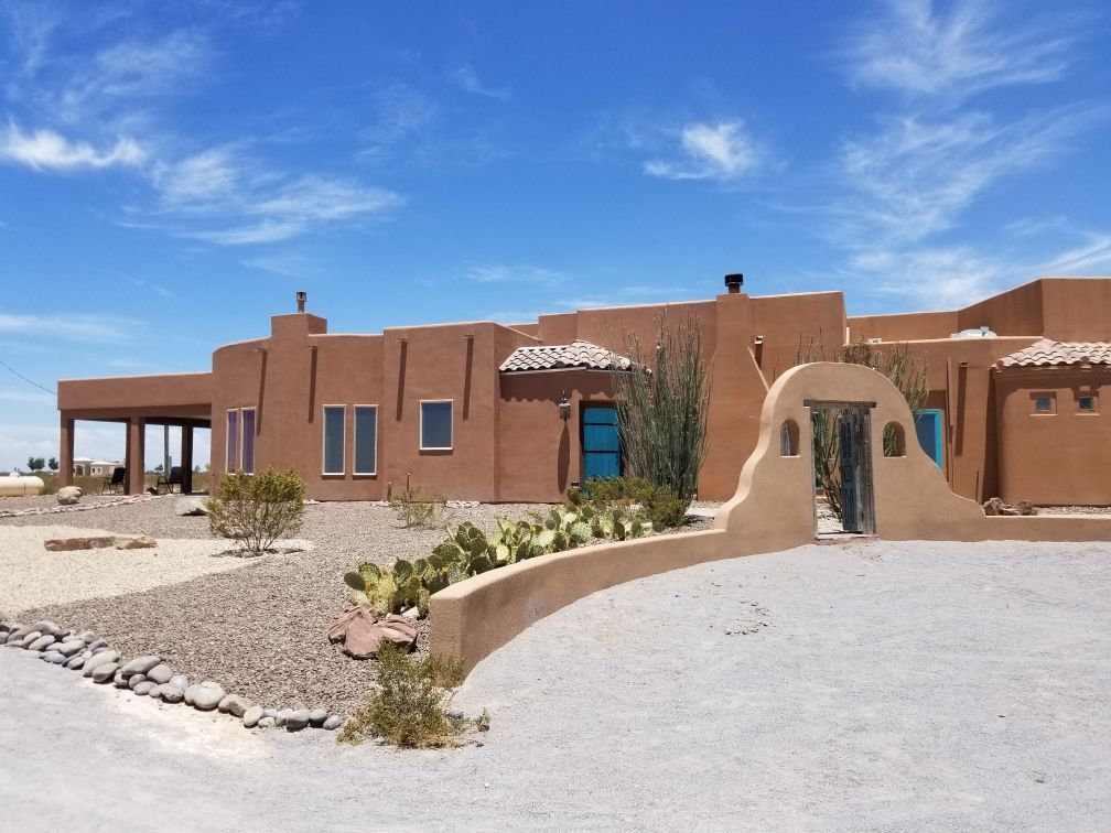 A large adobe house with a blue door