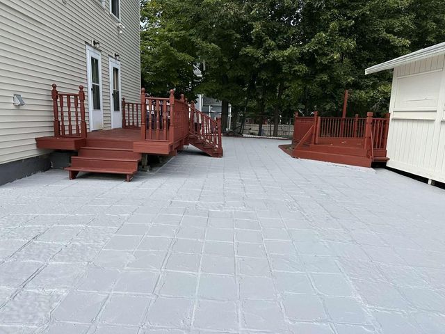 A large patio with a red deck and stairs in front of a house.