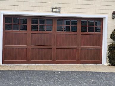 The garage door is made of wood and has a lot of windows.
