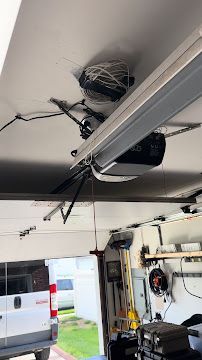 A garage door opener is hanging from the ceiling of a garage.