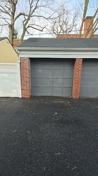 A garage with two garage doors and a brick wall.