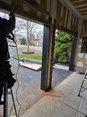 A man is working on a garage door with a drill.